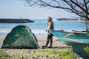 基林德Cozye Beach Camping Yala的站在海滩上船边的人