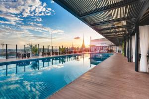 金边金边娱乐综合大楼酒店的一座享有日落美景的建筑中的游泳池