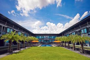 武里南武里南联阿玛瑞酒店的享有棕榈树和游泳池建筑的外部景色