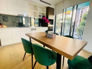 悉尼SPR Serivce Apartment Zetland 2 bedrooms 3 beds的厨房配有木桌和绿色椅子