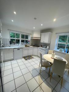 牛津Beautiful 5 Bedroom House Oxford - Sleeps 10的厨房配有白色橱柜和桌椅