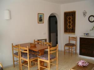 莫哈卡尔La Parata Apartments的一间带木桌和椅子的用餐室