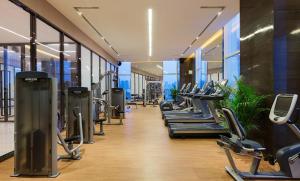 芜湖芜湖富力万达嘉华酒店的健身房,配有一排跑步机和机器