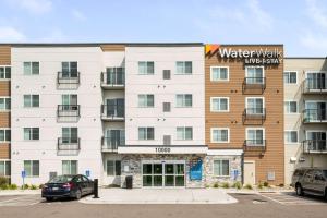 普利茅斯WaterWalk Extended Stay by Wyndham Minneapolis - Plymouth的停车场内有停车位的建筑物