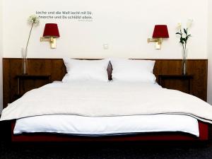 赫费尔霍夫赫费尔霍夫餐厅宾馆的一张带白色床单和两盏灯及鲜花的床