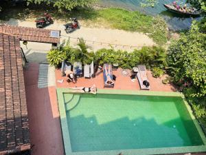 会安Hoi An Blue River Hotel的享有带躺椅的游泳池和海滩的顶部景致