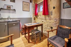 贝叶法国最小的房子度假屋的厨房配有桌子、椅子和水槽