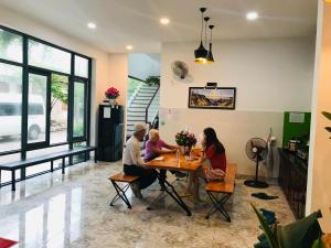 莲三Xóm Biển Homestay - Phú Yên的一群人坐在一个房间里桌子上