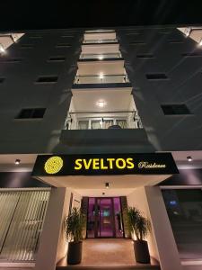 拉纳卡Sveltos Residence Suites的建筑上带有深红色标志的景观