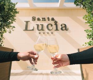 Santa LuċijaSanta Lucia Boutique Hotel的两人在香 ⁇ 丽舍大街标志前戴酒杯