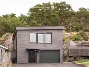 BilldalLuxury Modern Home near Gothenburg & 3 min t Beach的灰色的车库,设有窗户和一座建筑