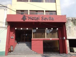 危地马拉塞维利亚酒店的一座红色的建筑,上面有医疗中心的标志