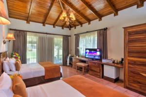 CulebraCC Beach Front Papagayo All Inclusive的一间卧室配有两张床和一台平面电视