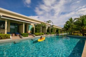 普吉镇CRAFT Resort & Villas, Phuket Town的度假酒店游泳池的木筏上的人