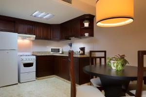 圣多明各佛罗里达州广场套房酒店的厨房配有黑桌和白色冰箱。