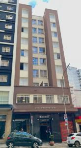 圣保罗Hotel Salomão - Próximo a 25 de Março, Bom Retiro, Brás e Rua Santa Efigênia, a 2 minutos do Mirante Sampa Sky e pista de Skate Anhangabaú的停在高楼前的汽车