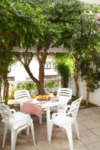 巴古尔Villa Sa Calma Beach Sa Riera的树木繁茂的庭院里摆放着白色的桌椅
