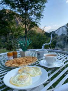 吉塔尔Chitral Green Guest House的餐桌,带两盘食物和一杯咖啡的桌子