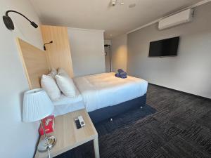 珀斯Econo Lodge Rivervale的一间酒店客房,配有一张床和一台电视