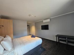 珀斯Econo Lodge Rivervale的一间酒店客房,配有一张床和一台电视