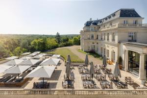 尚蒂伊InterContinental Hotels Chantilly Chateau Mont Royal, an IHG Hotel的享有大楼空中美景,配有桌子和伞