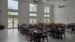 奥兰多SureStay Plus by Best Western Orlando Lake Buena Vista的用餐室设有桌椅和窗户。