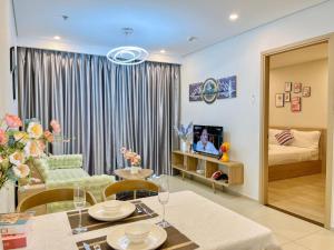 头顿Trang Homestay - The Sóng Apartment的一间带桌子的客厅和一间卧室