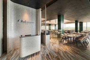 名古屋Oakwood Hotel & Apartments Grand Batam的一间在房间内配有桌椅的餐厅