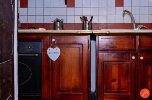 罗马特拉斯提弗列华丽公寓的厨房配有木制橱柜和带标签的盥洗池