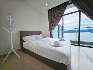 哥打京那巴鲁Summer Seaview Studio Apartment at Kota Kinabalu City Centre的一间卧室设有一张床和一个大窗户