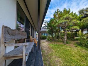 Nishioguest house Ki-zu - Vacation STAY 92940的坐在房子门廊上的木凳