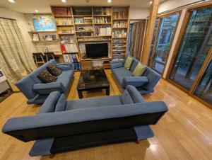 Nishioguest house Ki-zu - Vacation STAY 92940的客厅配有2张蓝色沙发和壁炉