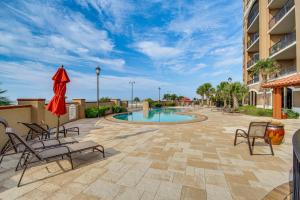 格尔夫波特Sleek Gulfport Condo with Ocean Views and Pool Access!的一个带椅子的庭院和一个位于度假村的游泳池