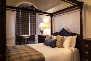 阿洛厄英格尔伍德之家及Spa中心酒店的一间卧室配有一张带桌椅的天蓬床