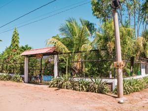 拉斯彭尼塔斯Beach House In Las Penitas Leon的一条棕榈树街道旁的围栏