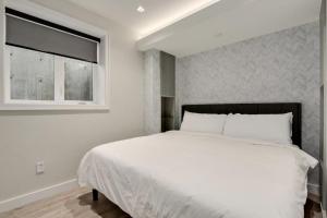 温哥华Designer 2BR in Downtown Steps from Sunset Beach的卧室配有白色的床和窗户。