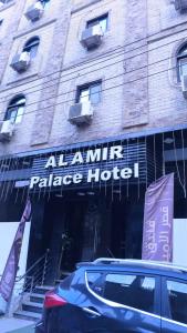 索哈杰Al Amir Palace Hotel的停在宫殿酒店前的汽车