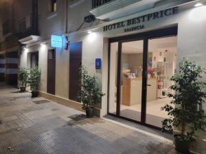 瓦伦西亚Hotel BESTPRICE Valencia的建筑前有盆栽植物的商店