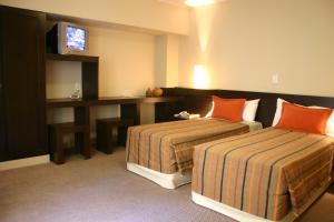 门多萨蓝带马德普拉塔酒店的酒店客房 - 带两张带橙色枕头的床