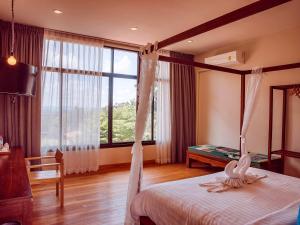 Ban Sap NoiTantai Eco Farm Stay At Khao Yai的一间卧室设有一张天蓬床和大窗户