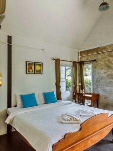 Ban Sap NoiTantai Eco Farm Stay At Khao Yai的一间卧室配有一张带蓝色枕头的大床