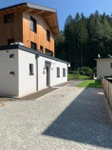 因斯布鲁克Waldblick - modern wohnen - Self-Check-In - direkt am Wald - kein Verkehr - in 10 Minuten im Innsbrucker Zentrum - vorm Haus parken的建筑前有石头车道的建筑