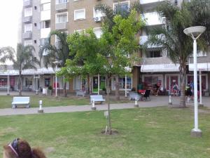 科尔多瓦Departamento Temporario Villa Sol的建筑前有长椅和树的公园