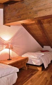 尚波吕克Meublè Lo Miete Viei的一间卧室配有两张床和一张带台灯的桌子