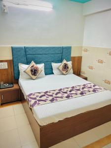 NarodaHotel Ashadeep palace的一间卧室配有一张大床和枕头