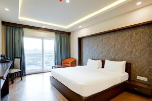 新德里Hotel Blue Krone Near Delhi Airport的一间设有大床和窗户的酒店客房