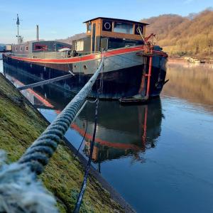 AndenneUne perle ! Péniche complète pour 8 sur la Meuse, région Namur的一艘大船停靠在水中