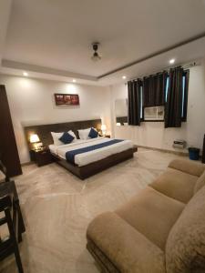 新德里Hotel The Paradise In - Near Karol Bagh Metro Station的一间大卧室,配有一张床和一张沙发