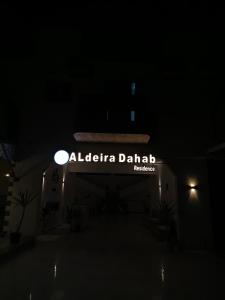 达哈布Al Deira Dahab Residence的夜间用达拉迪的爱丽丝达表示的标志