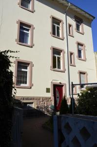 巴登-巴登费力翁席罗思酒店的白色的建筑,设有窗户和红色的门